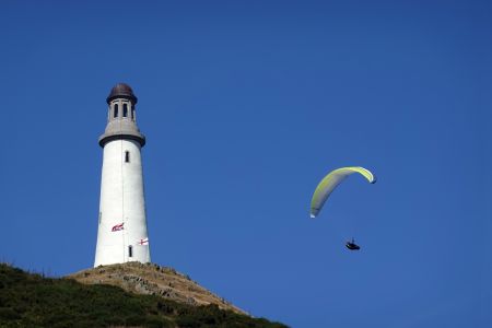 Letec na paraglidu krouží kolem rozhledny Hoad Monument.